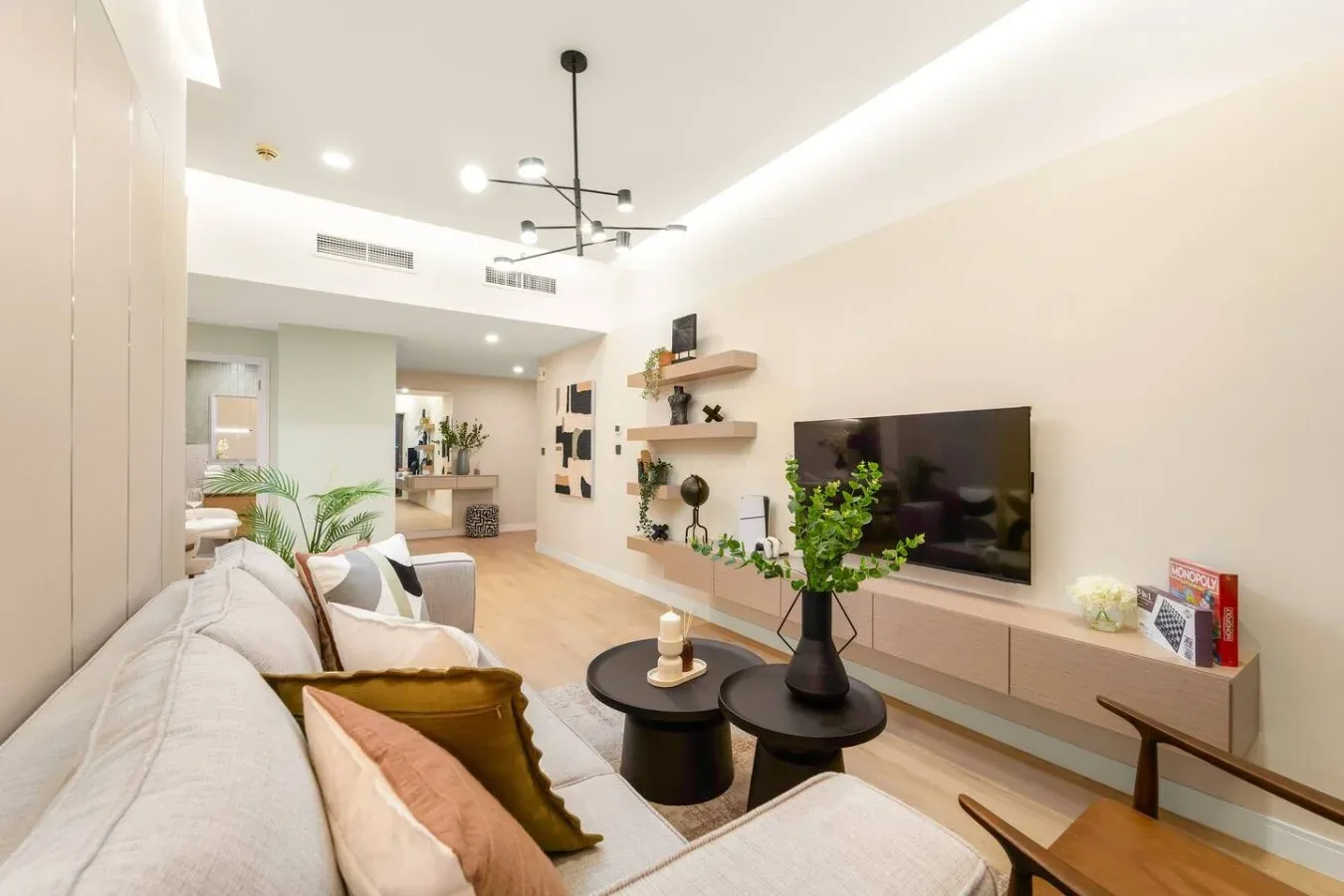 A bright living room with seating, a television, and a coffee table.