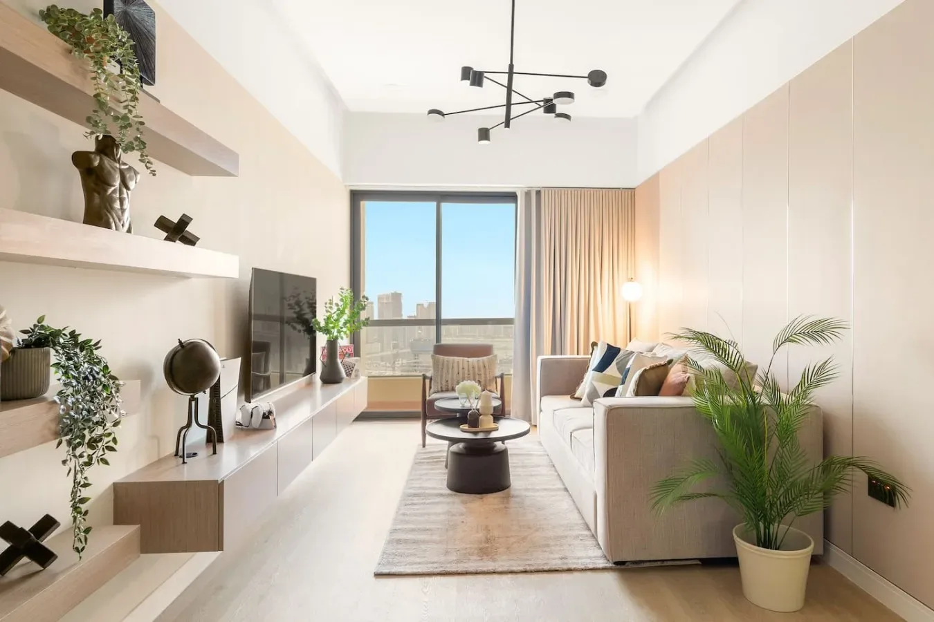 A bright living room with seating, a coffee table, and a large window.