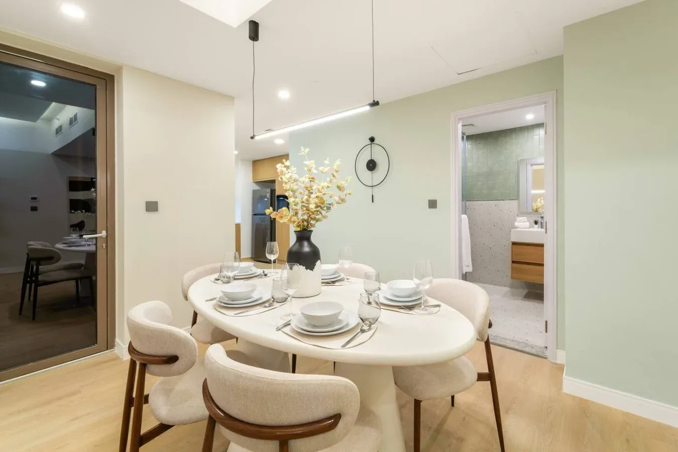 A dining area with a set table and chairs beside an open doorway.