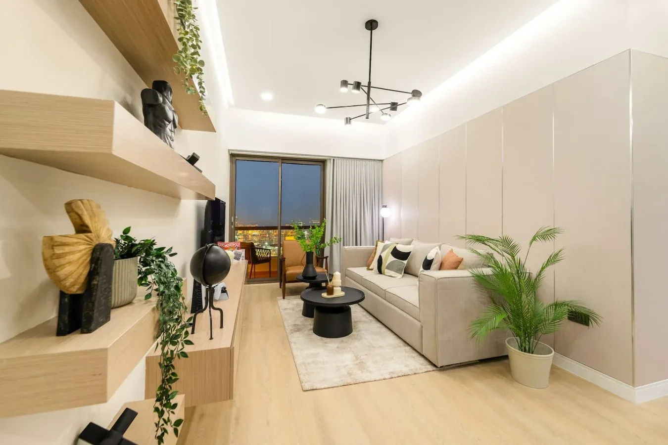 A modern living room with a sofa, coffee table, and large window.