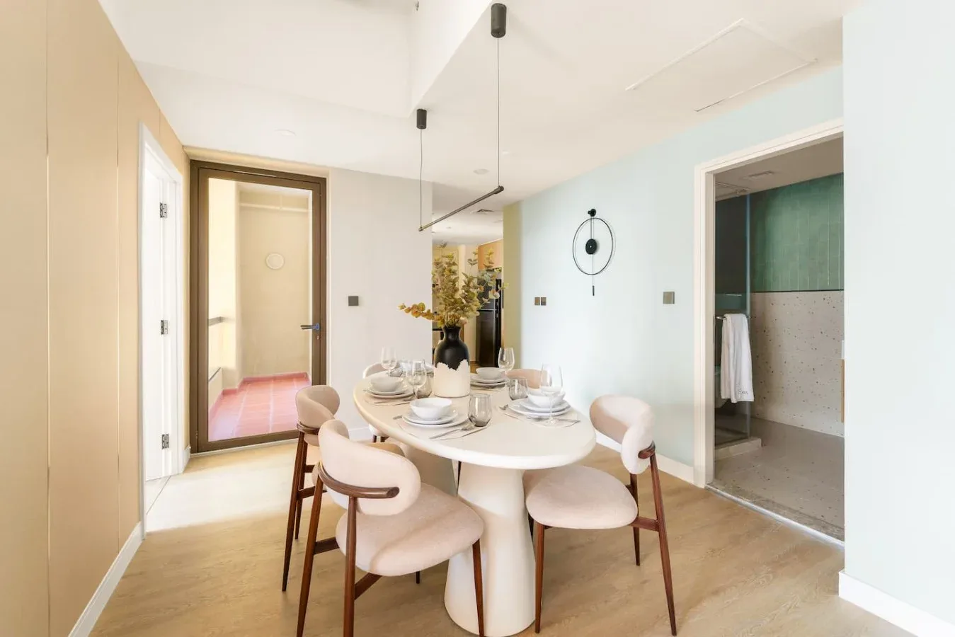 A dining area with a set table and an open doorway to a bathroom.