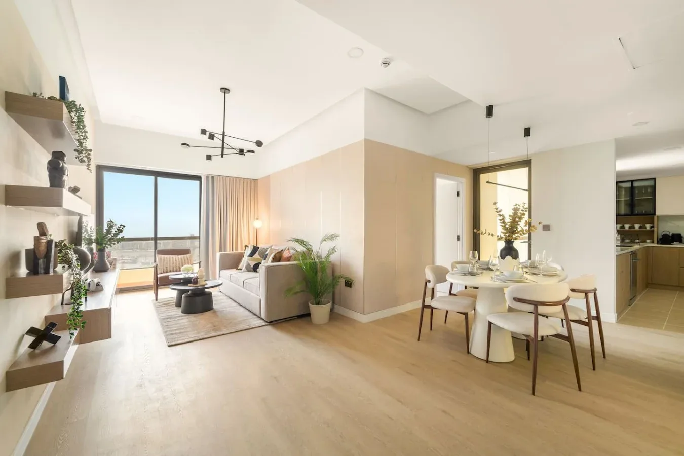 A bright open-plan living and dining area with seating beside large windows.