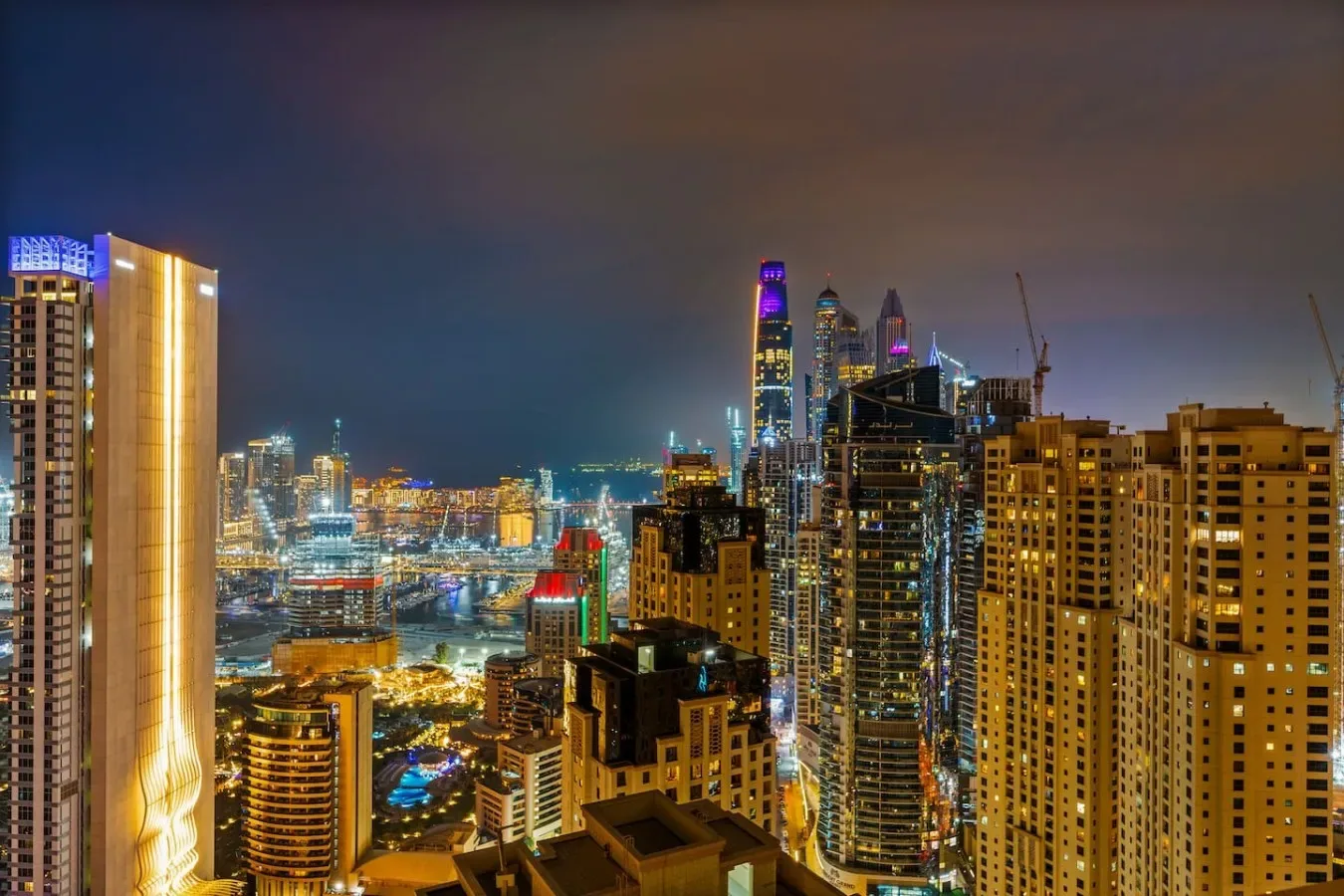 Un horizonte urbano nocturno con edificios altos iluminados.