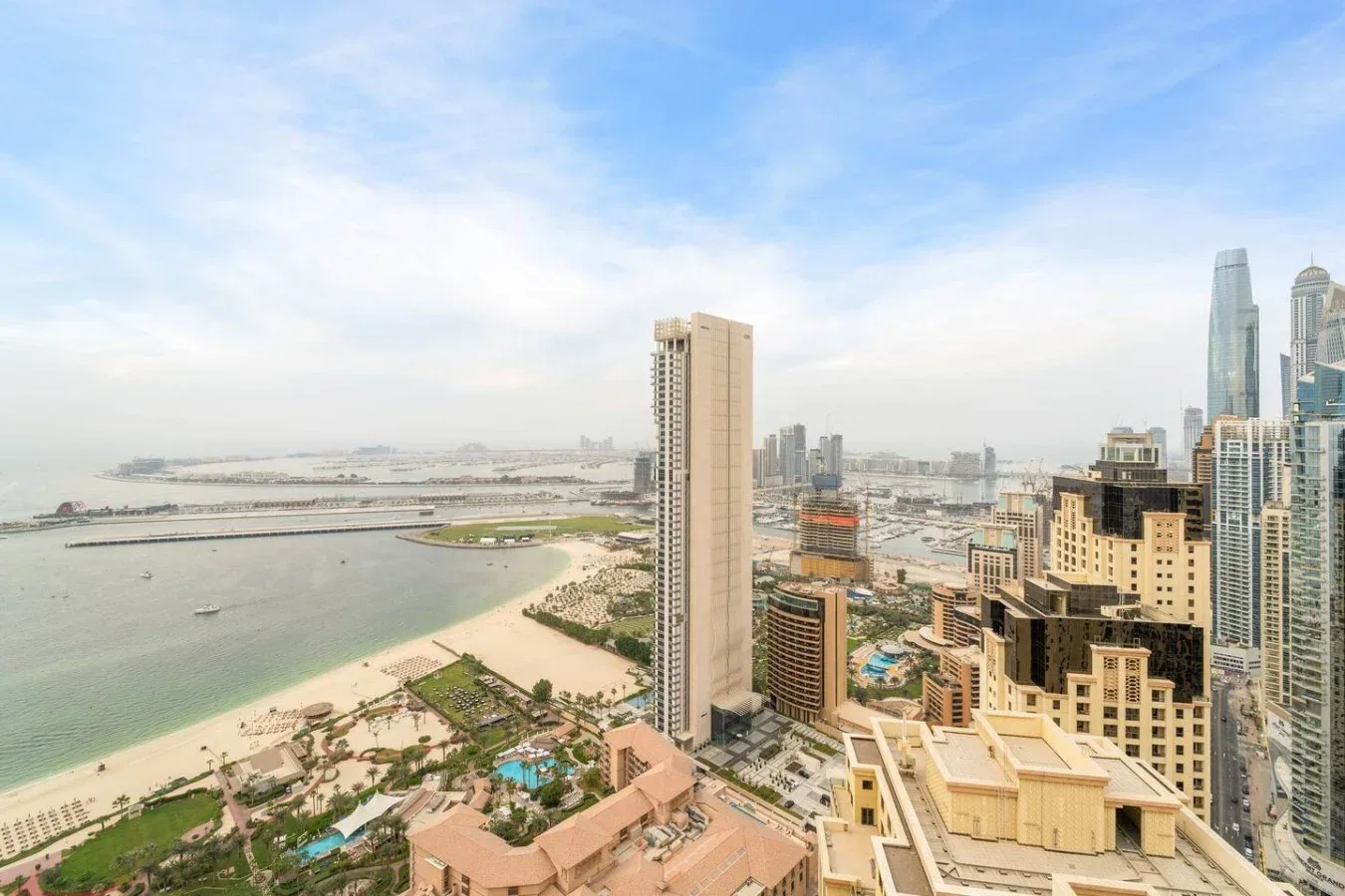 A coastal city skyline with high-rise buildings beside a curving waterfront.