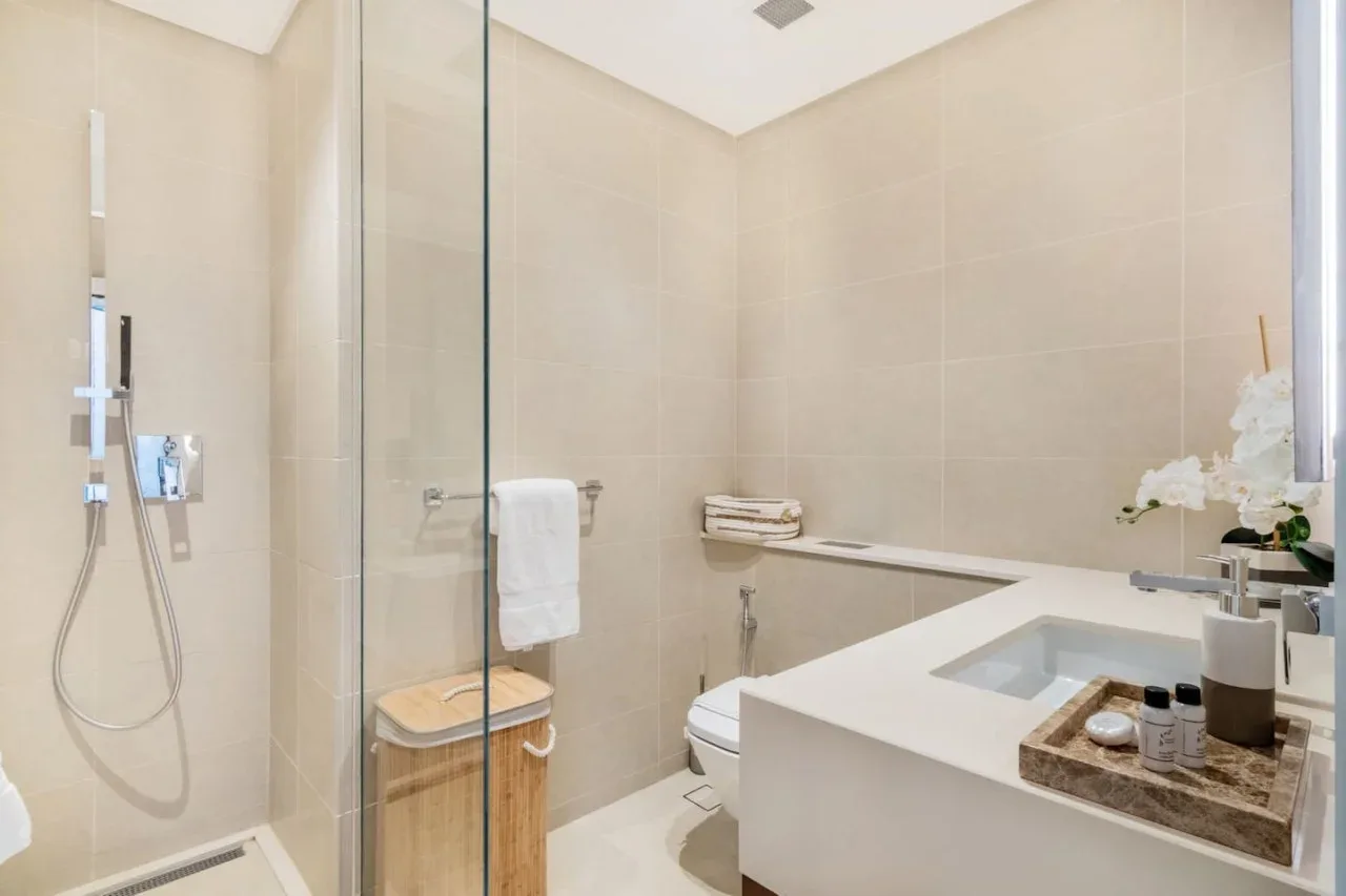 A tiled bathroom with a glass shower and a large bathtub.