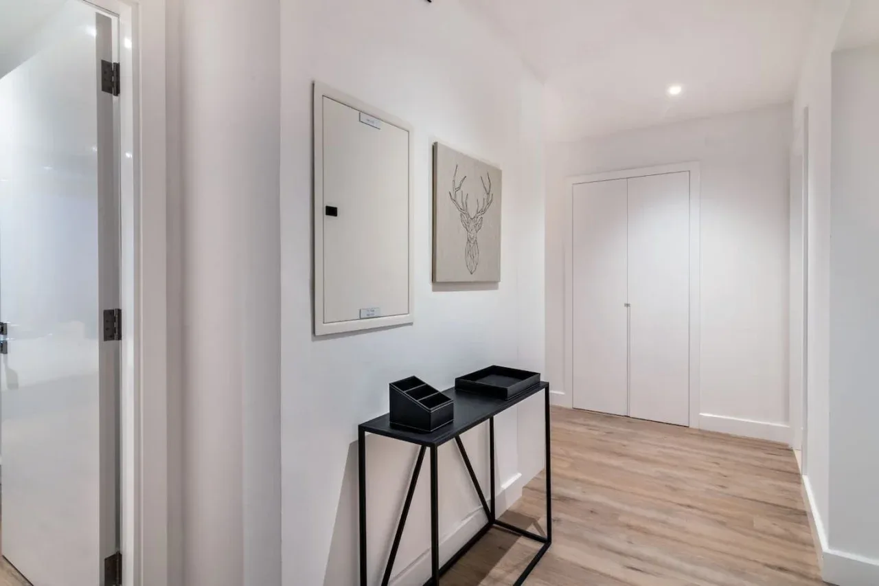 A bright hallway with a narrow console table and framed wall art.