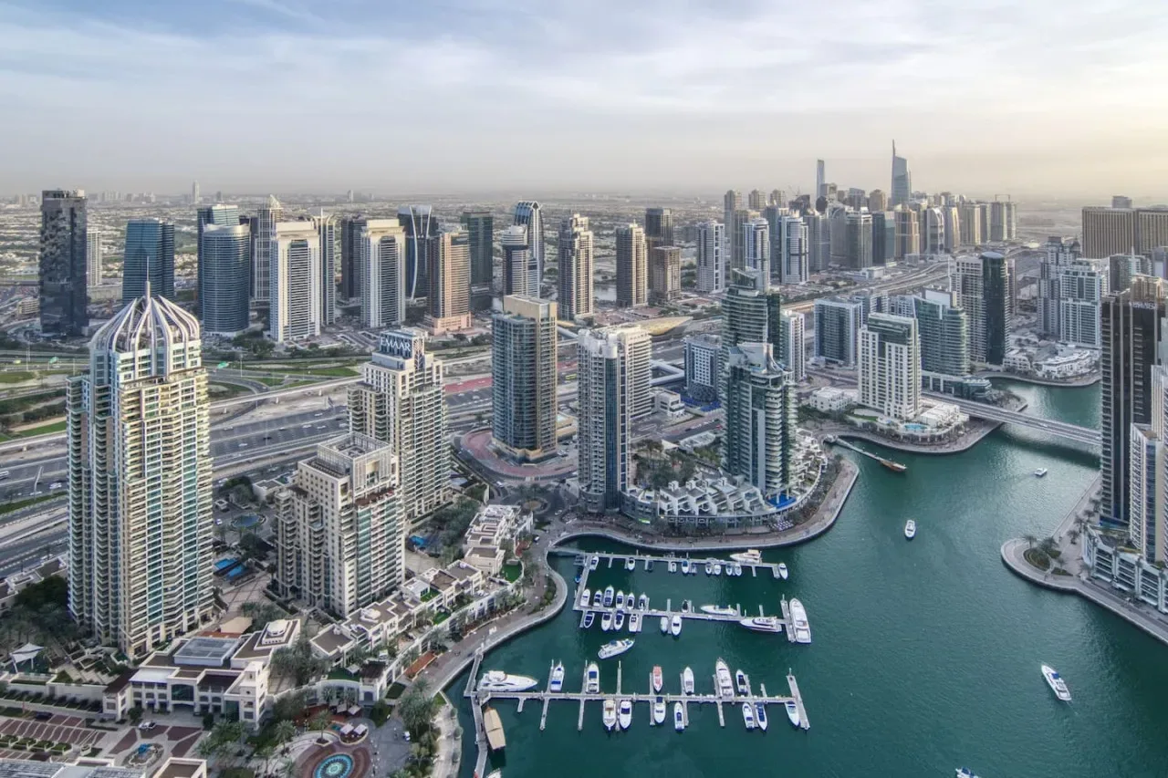 Vista aérea de un horizonte urbano junto al agua, con edificios altos y una marina.