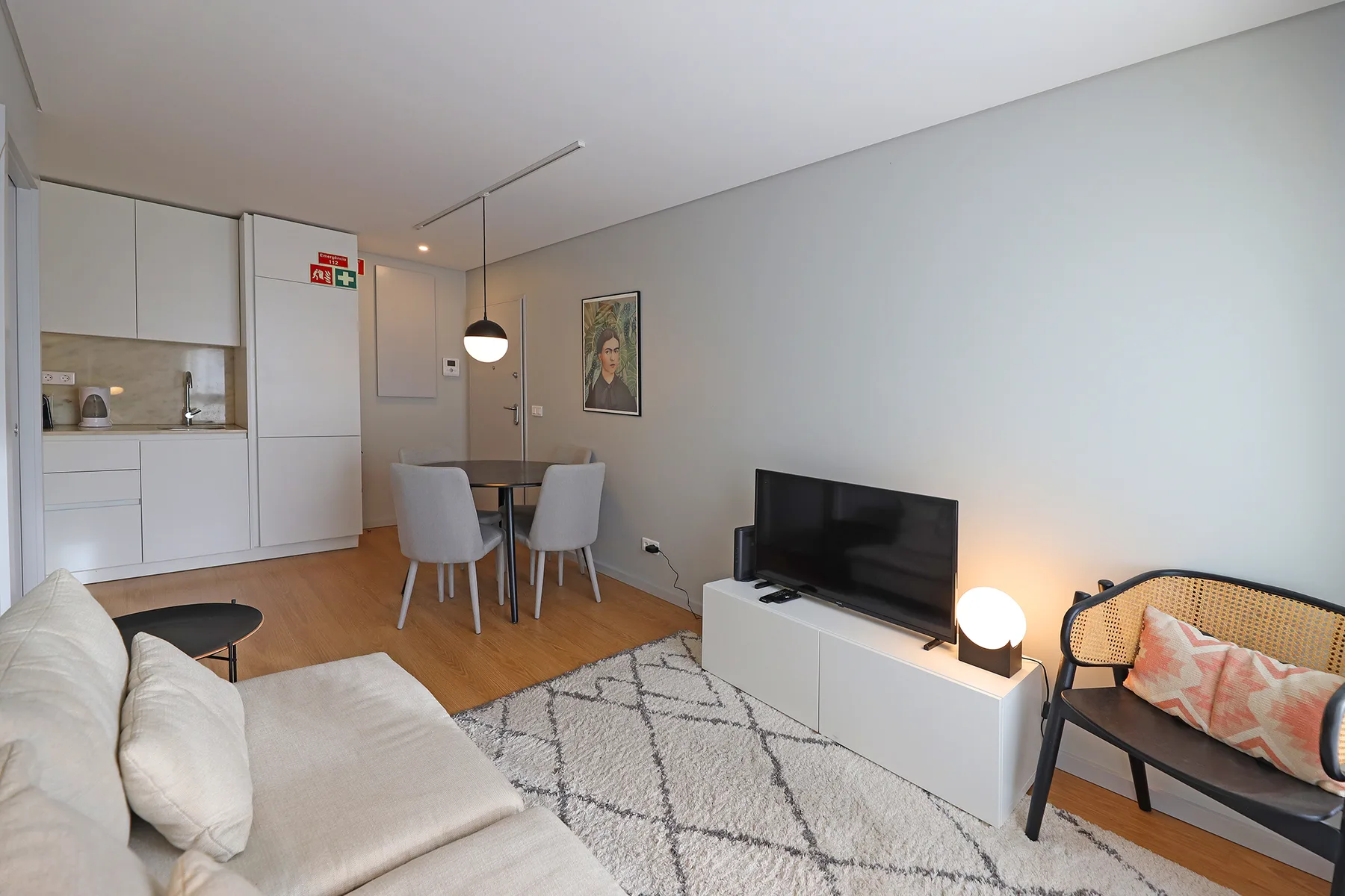 A living and dining area with a television and compact kitchen.