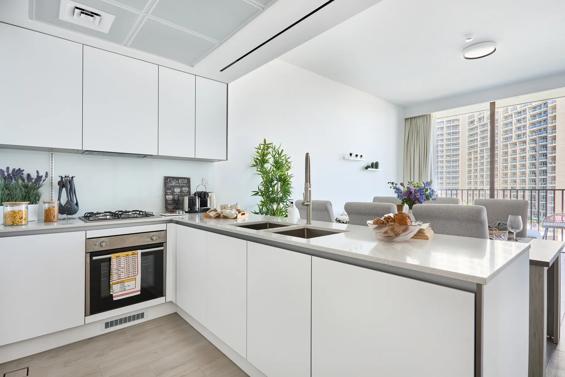 Una cocina moderna y luminosa con gabinetes blancos y una isla grande.
