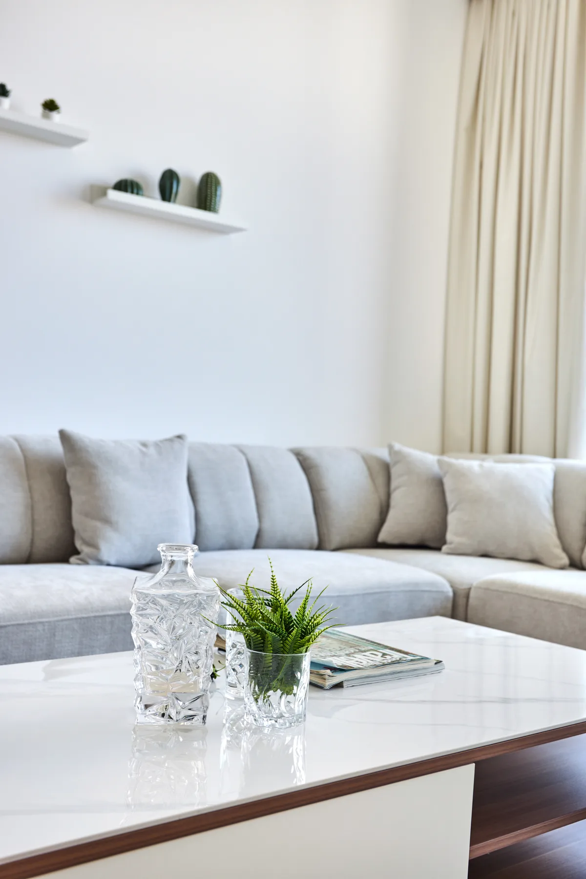Una sala luminosa con un sofá seccional claro y una mesa de centro.