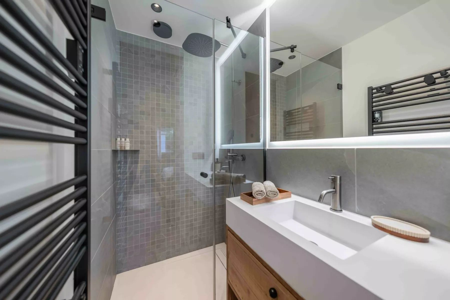 Un baño moderno con una ducha de vidrio y un lavabo amplio.