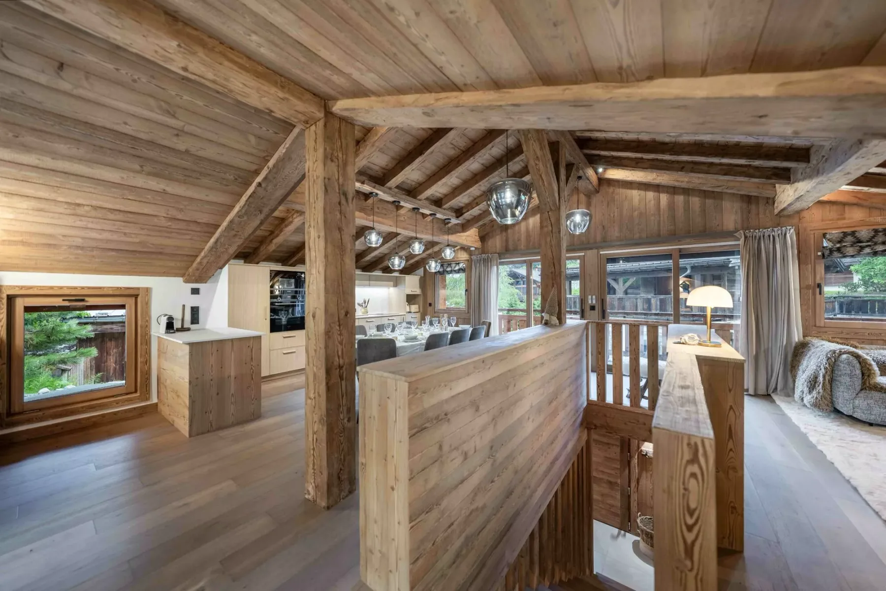 Una amplia sala revestida de madera con mesa de comedor y ventanales.