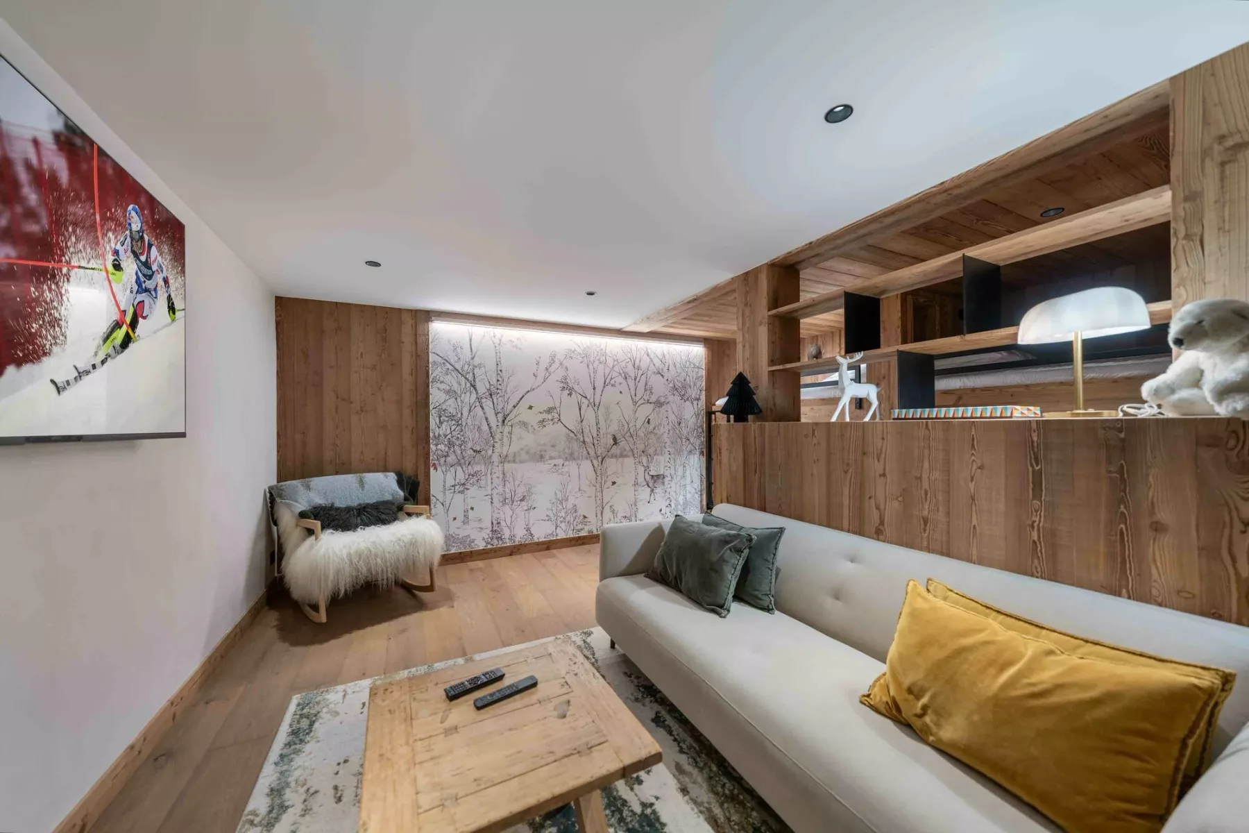 Una sala de estar con sofá claro, mesa de centro de madera y estanterías empotradas.
