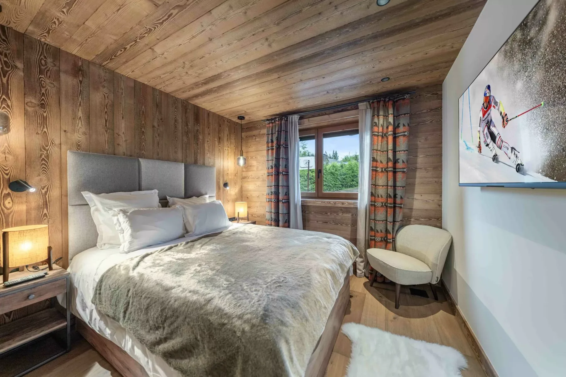 Un dormitorio con una cama bien tendida y una ventana con vistas a zonas verdes.