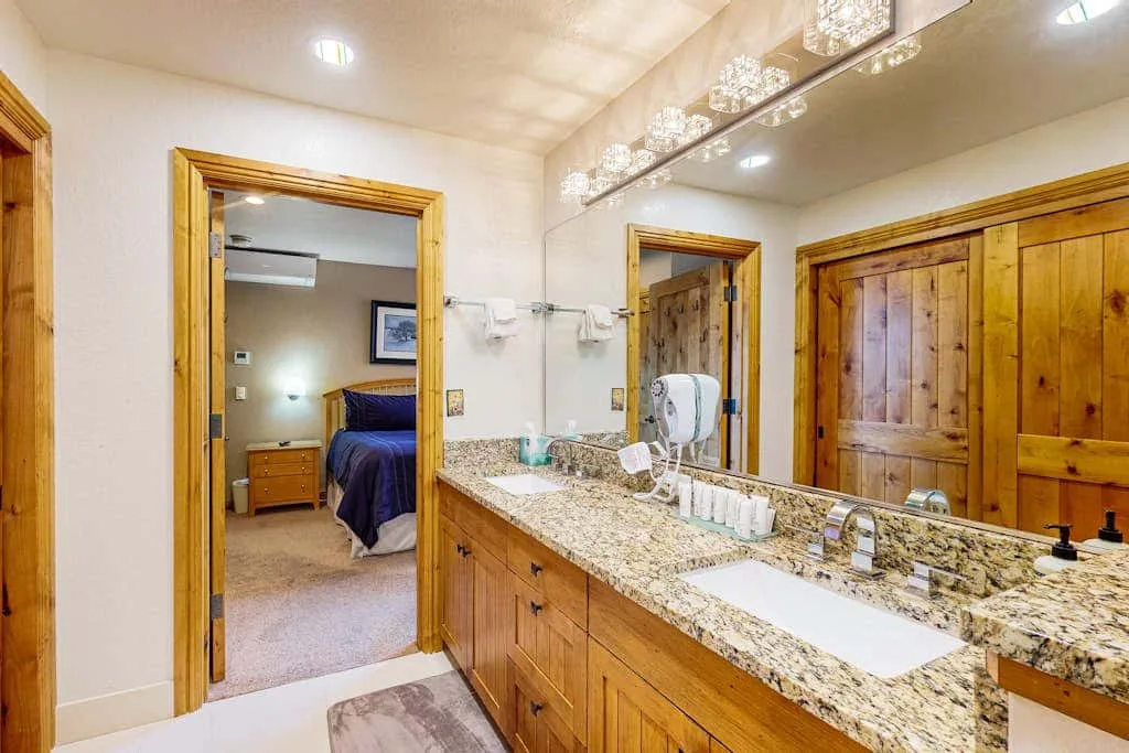 A bathroom vanity with a long countertop and a large mirror.