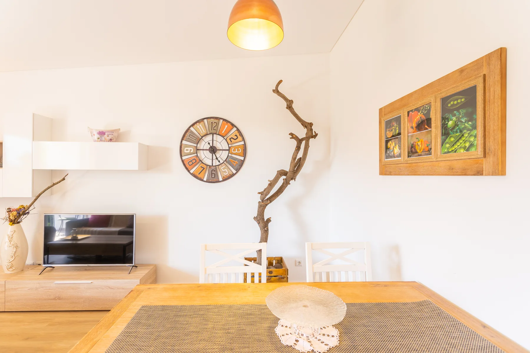Comedor con una mesa de madera, sillas y adornos en la pared.