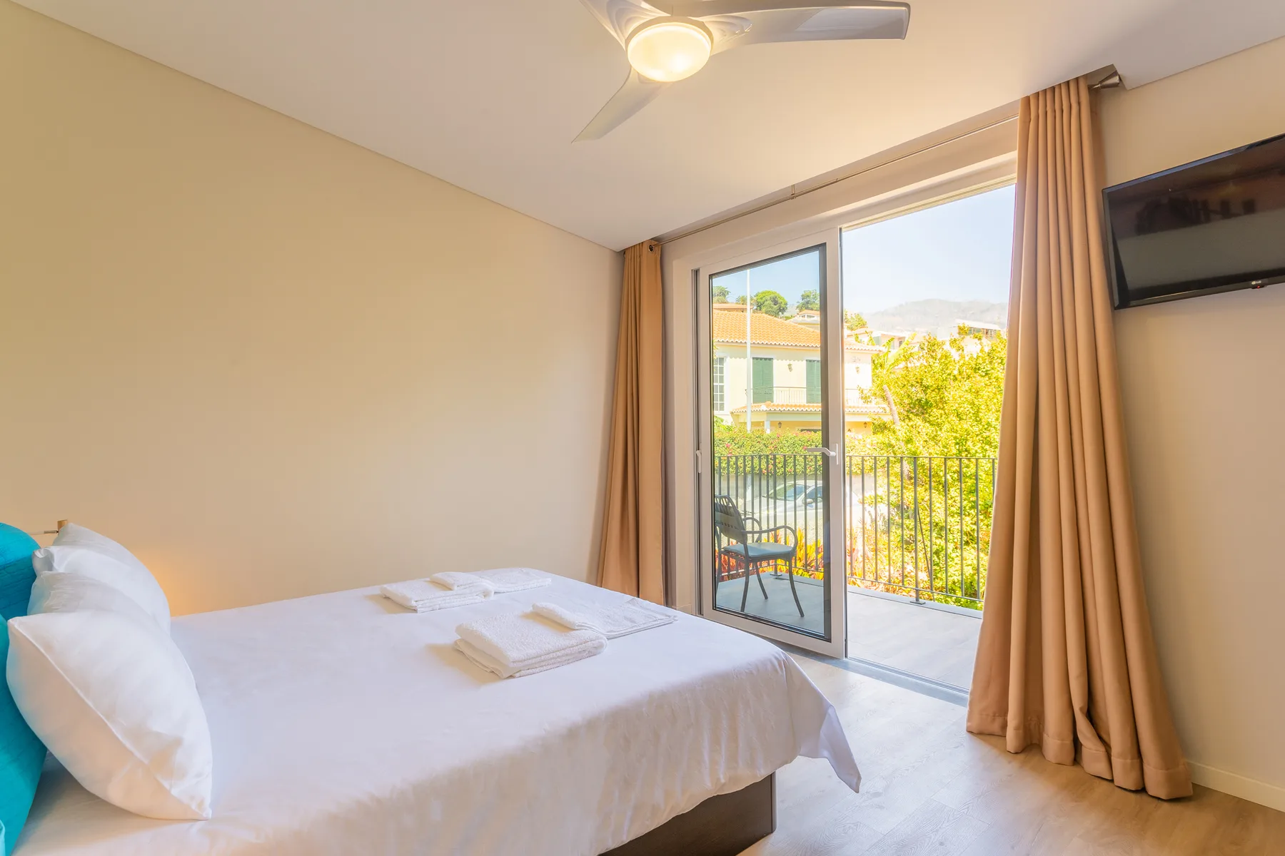 Un dormitorio con una cama junto a puertas corredizas de vidrio que dan a un balcón.
