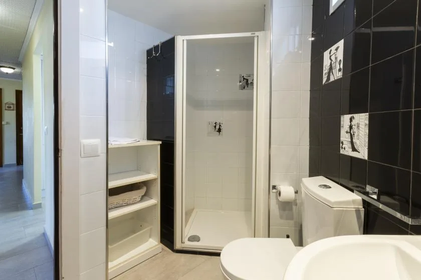 A tiled bathroom with a shower, toilet, and sink.
