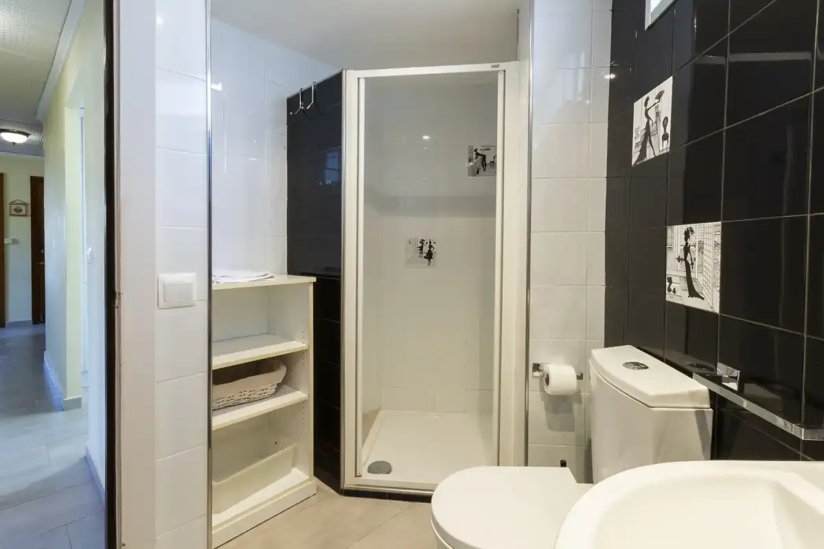 A tiled bathroom with a shower, toilet, and sink.