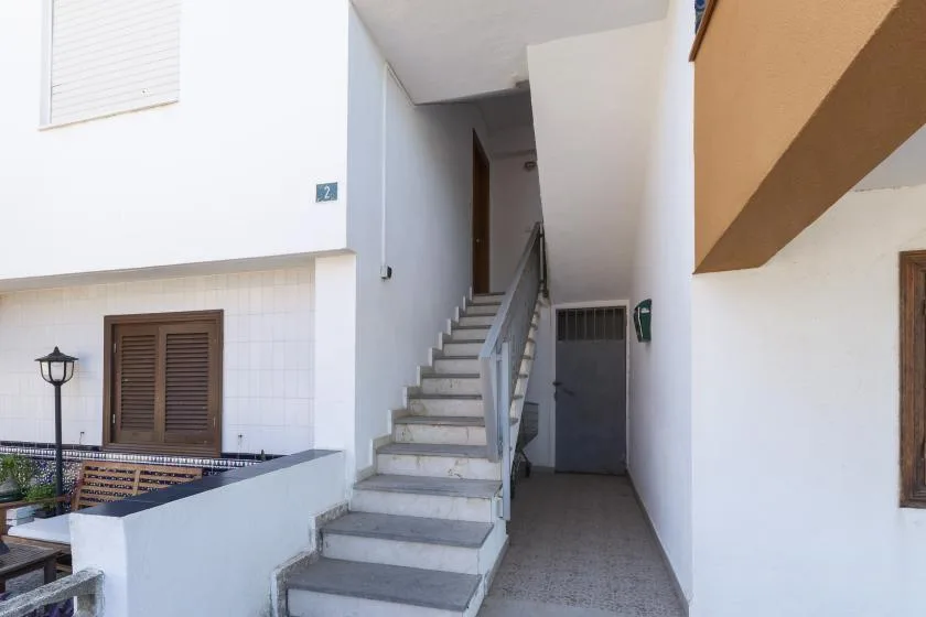 An indoor stairwell with a staircase and a hallway beside it.