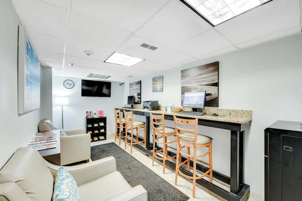 A lounge and computer area with counter seating and a sofa.