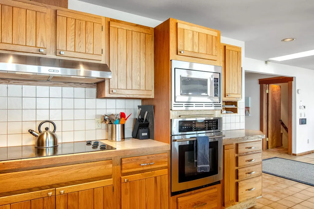 A kitchen with wooden cabinets and a built-in oven and microwave.