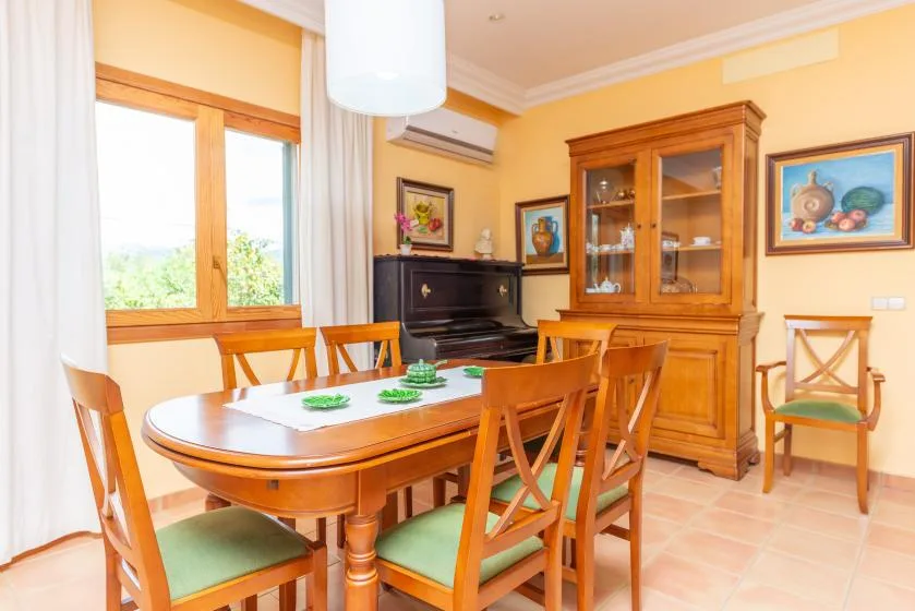 A dining room with a wooden table and chairs beside a glass-front cabinet.