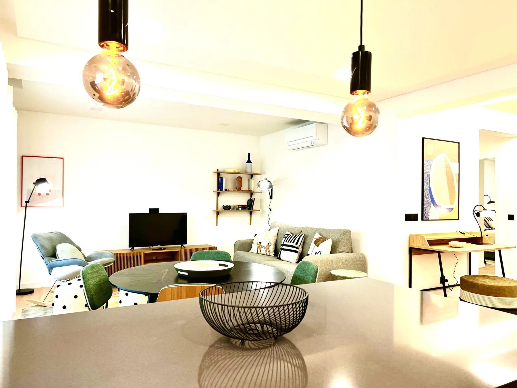 Una sala luminosa con asientos, un televisor y una mesa de comedor.
