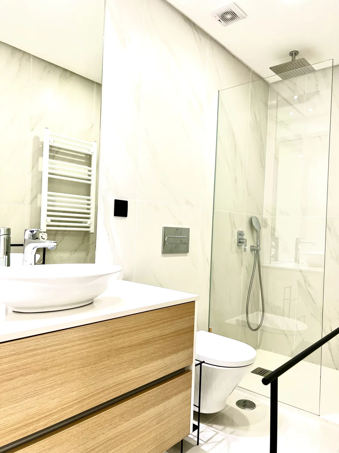 Un baño luminoso con lavabo y ducha de cristal.