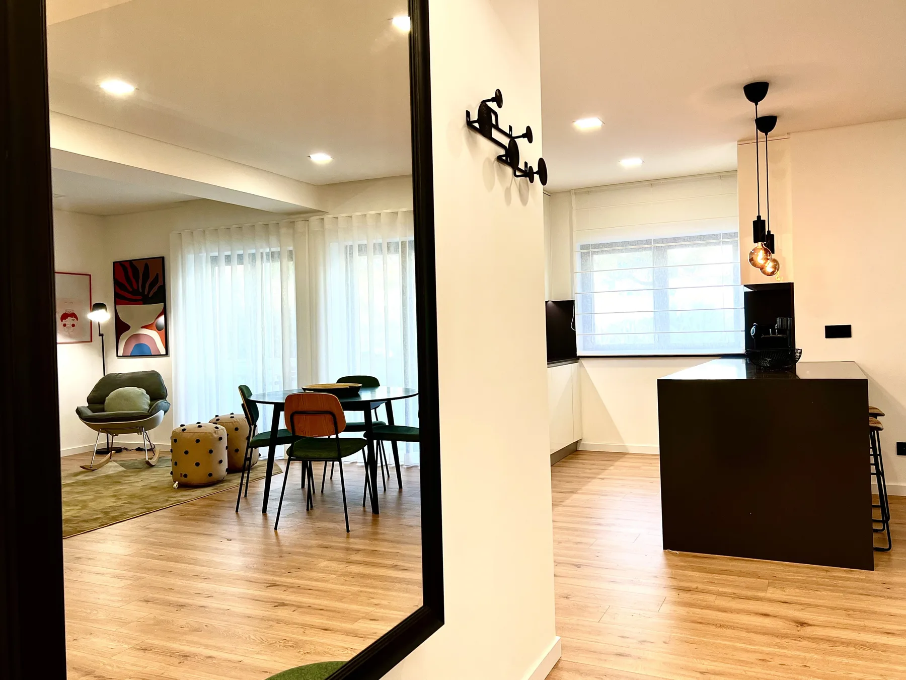 Un interior de apartamento diáfano con zona de comedor e isla de cocina.