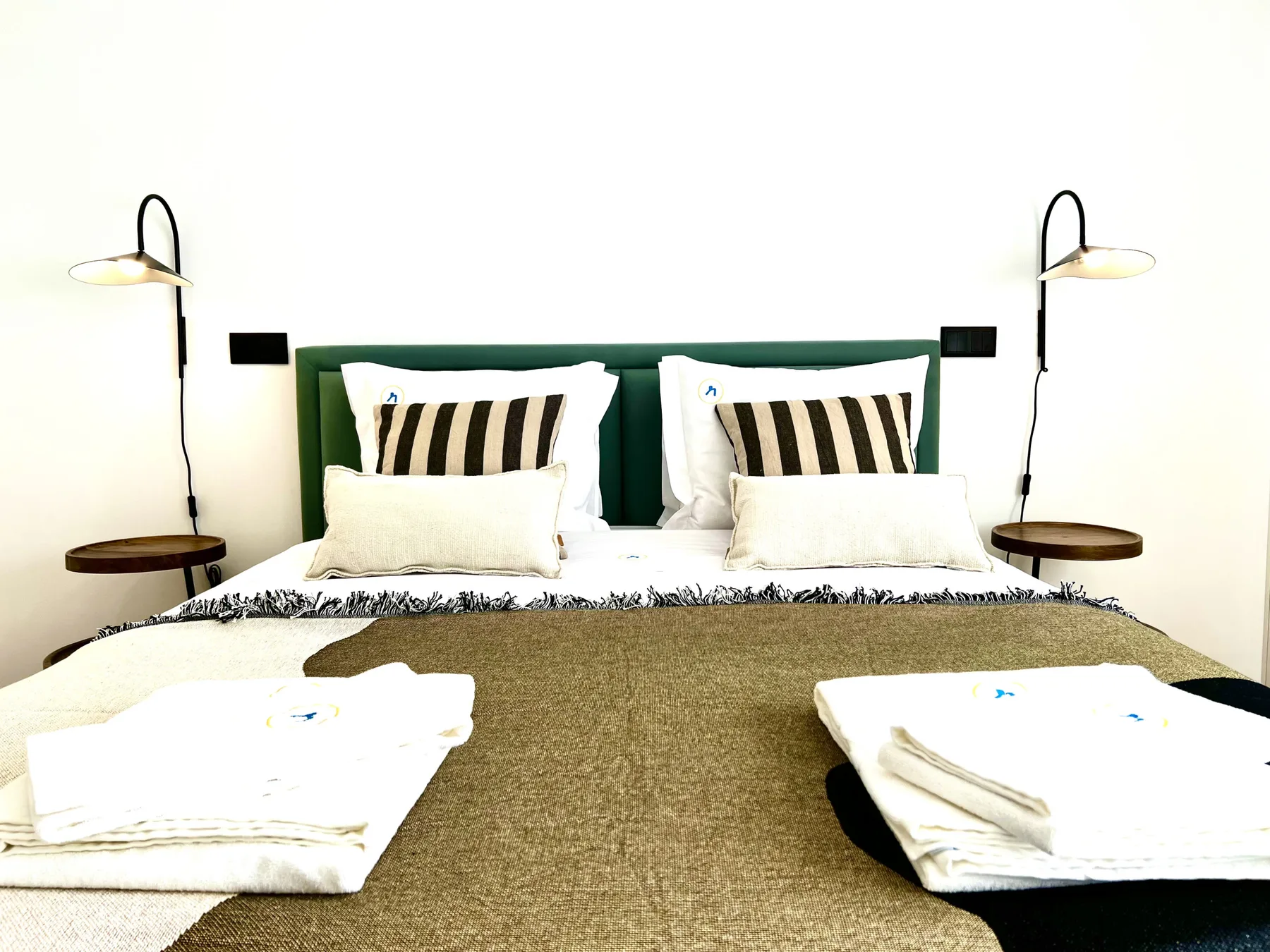 Un dormitorio con una cama bien arreglada y toallas dobladas.