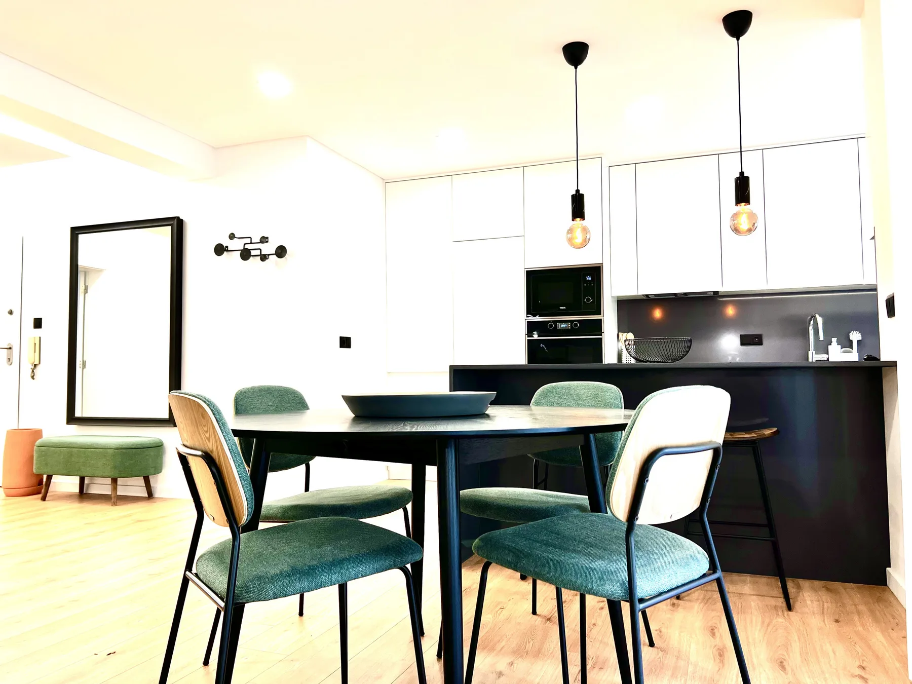 Un comedor con mesa y sillas junto a una cocina moderna.