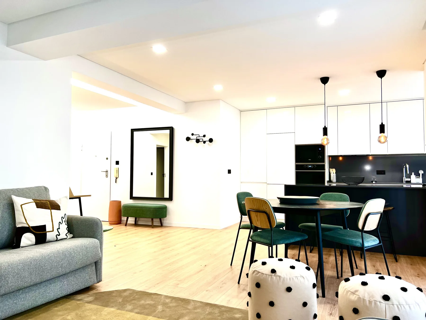 Una luminosa sala de estar y comedor de planta abierta con cocina y mesa de comedor.