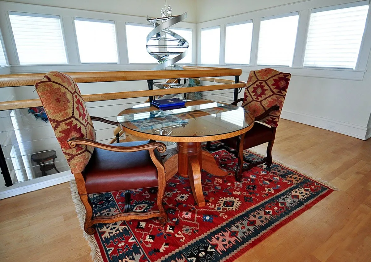 Comedor con una mesa de vidrio y asientos estampados.