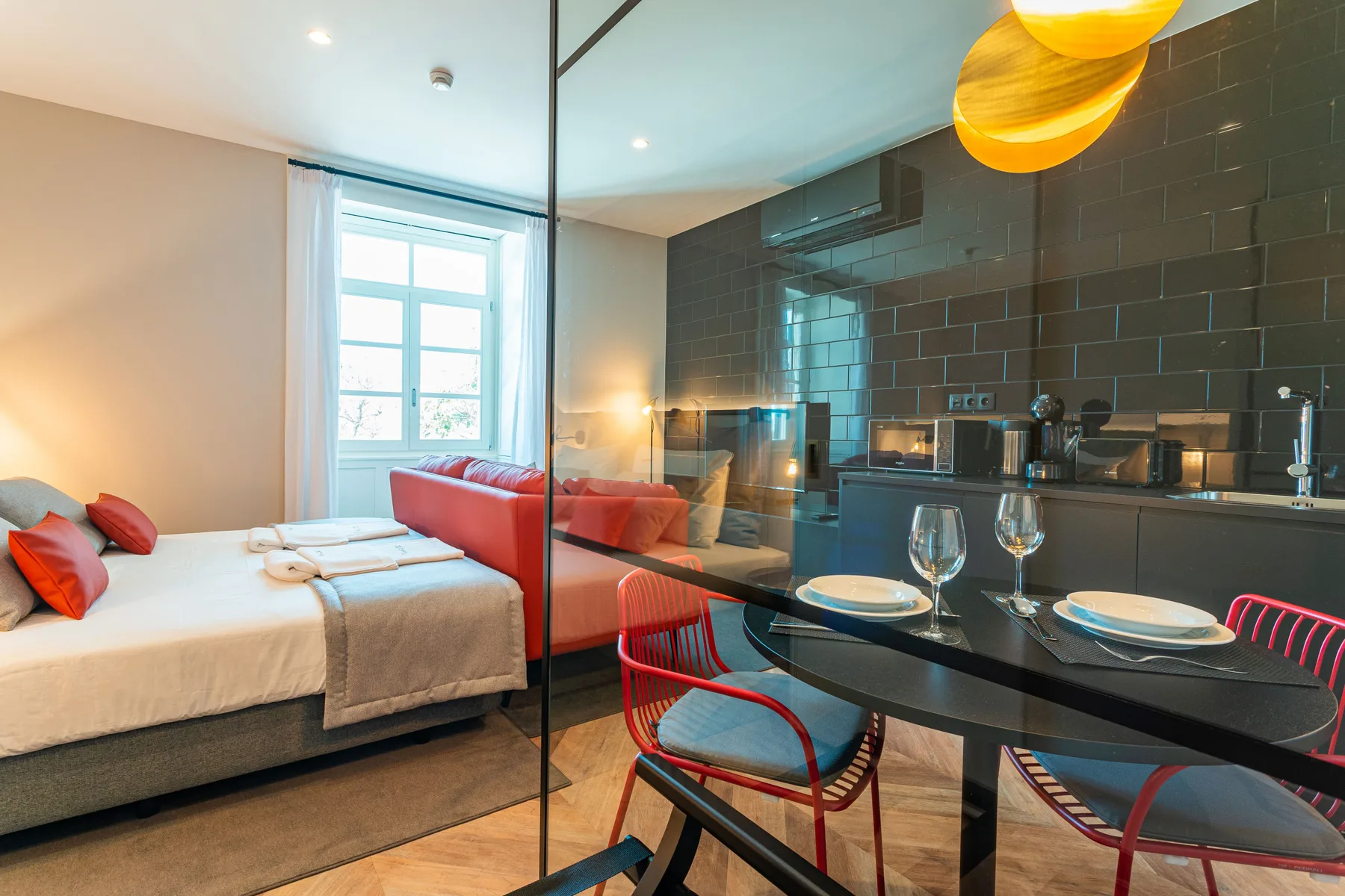 A studio interior combines a sleeping area, kitchenette, and dining table.