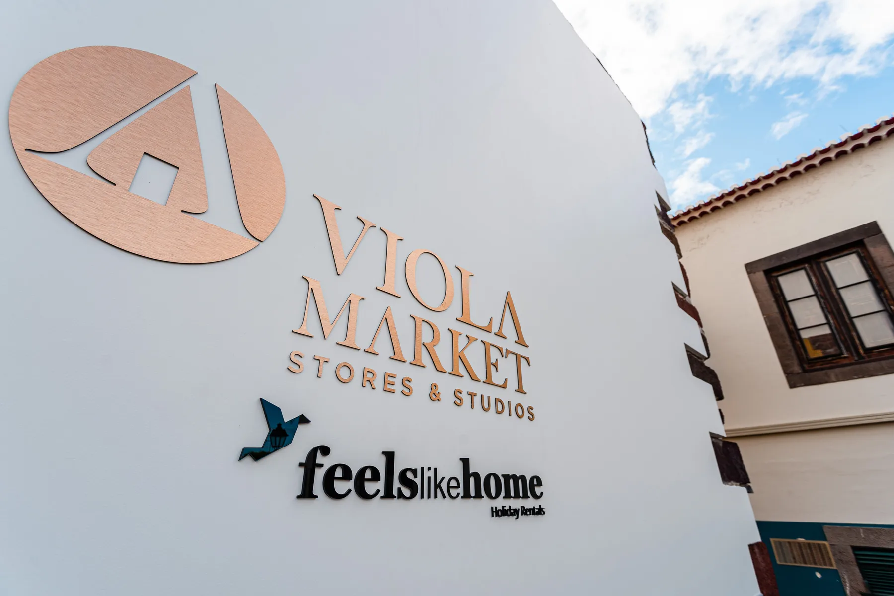 A white exterior wall displays the Viola Market Stores & Studios sign.