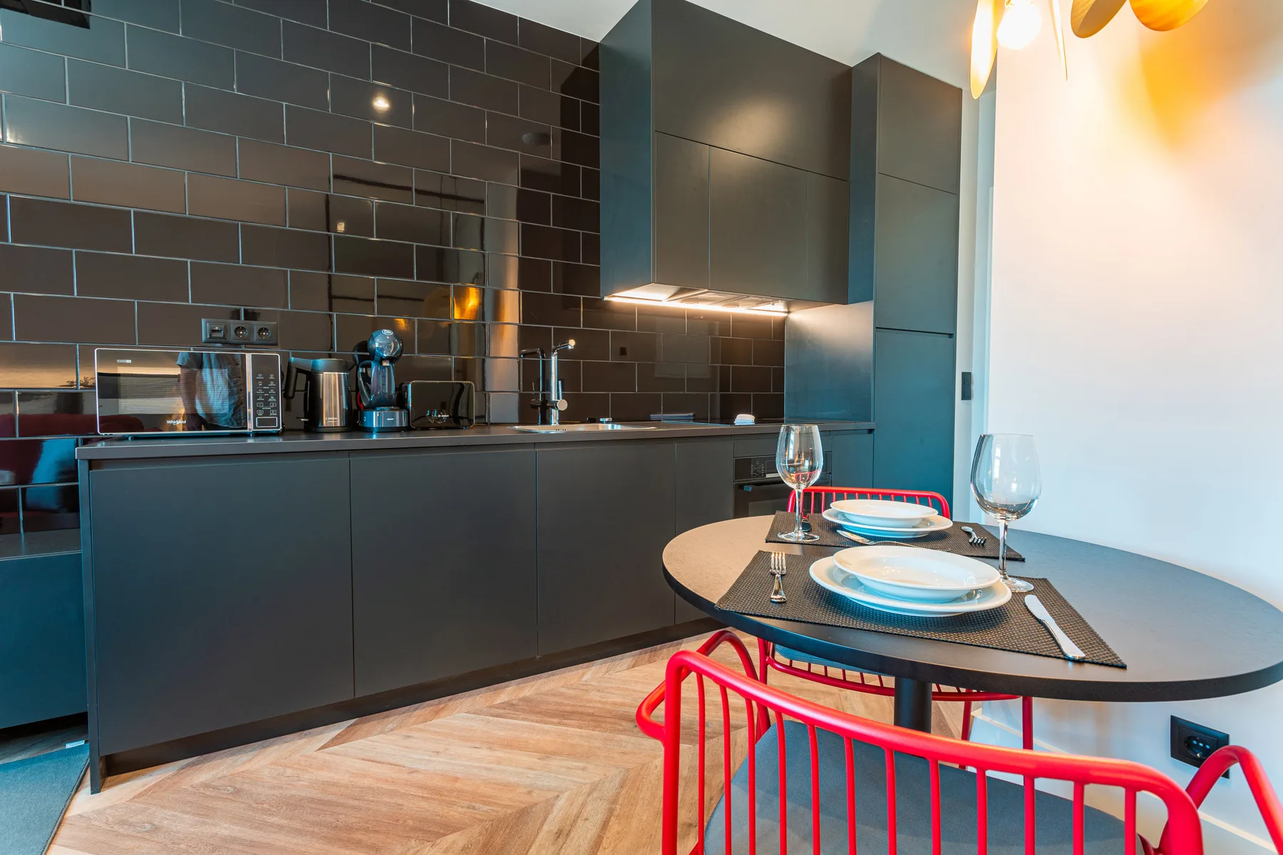 A modern kitchen and dining area with a table set beside the counter.
