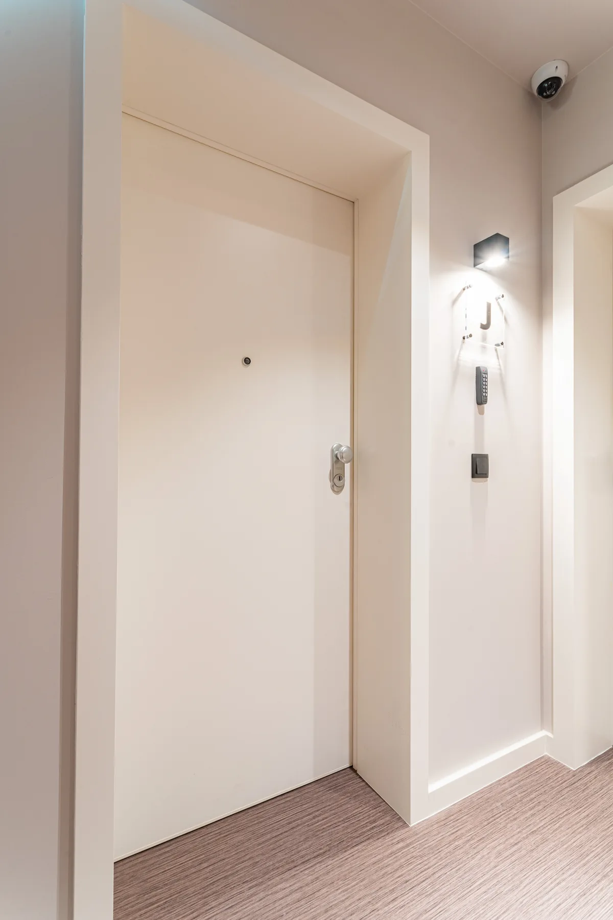 An interior entryway with a closed door and wall-mounted intercom.
