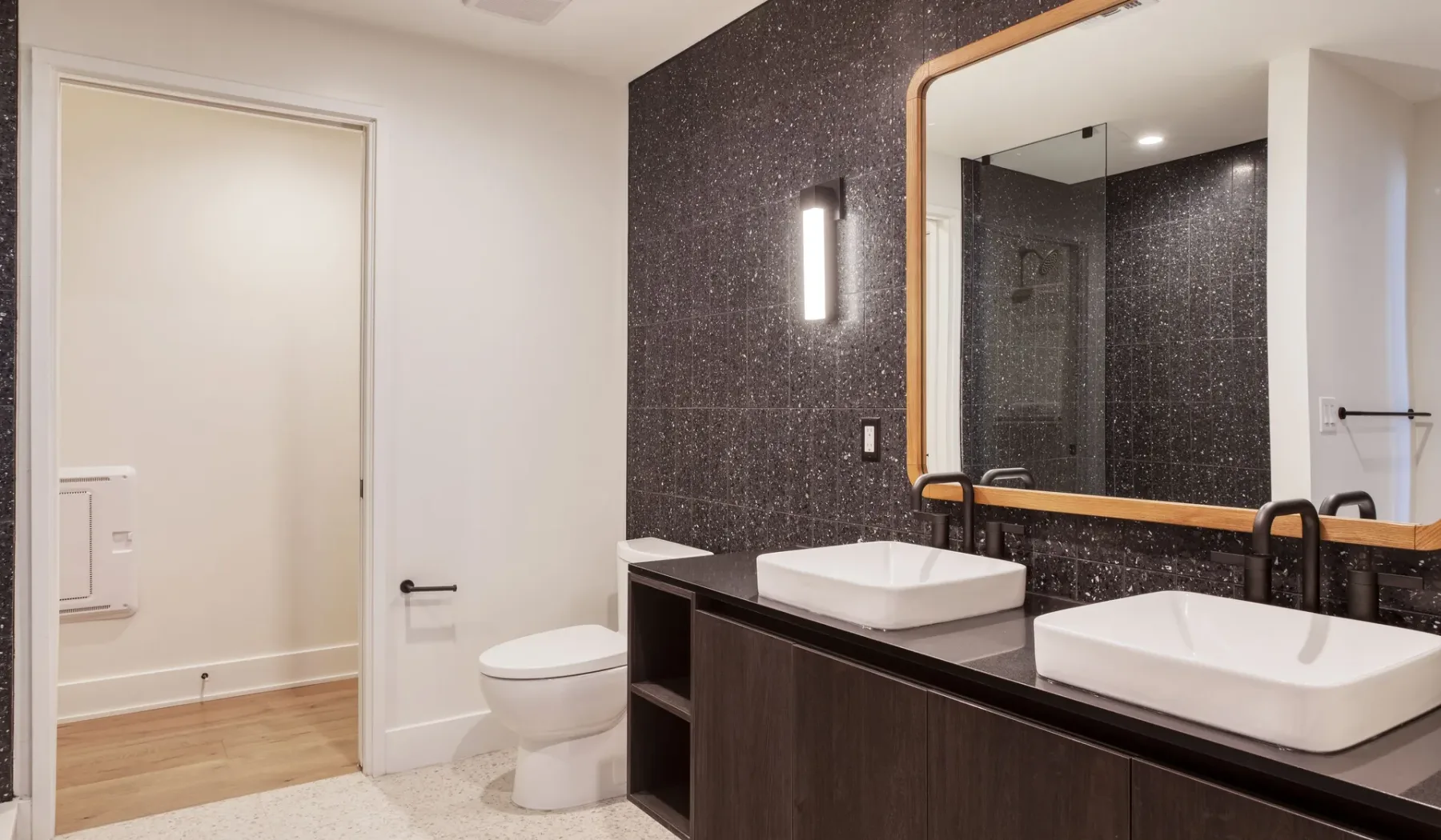A modern bathroom with a double vanity and a large mirror.