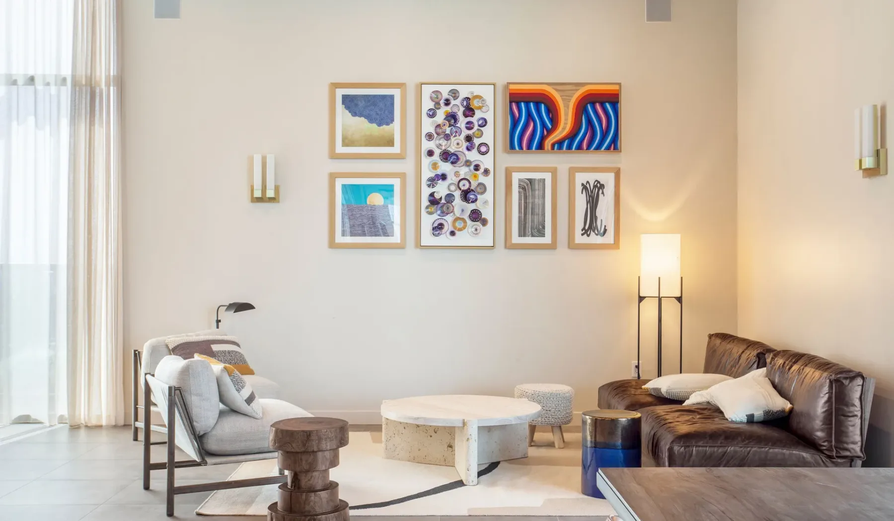 A bright living room with seating, a low table, and framed artwork.