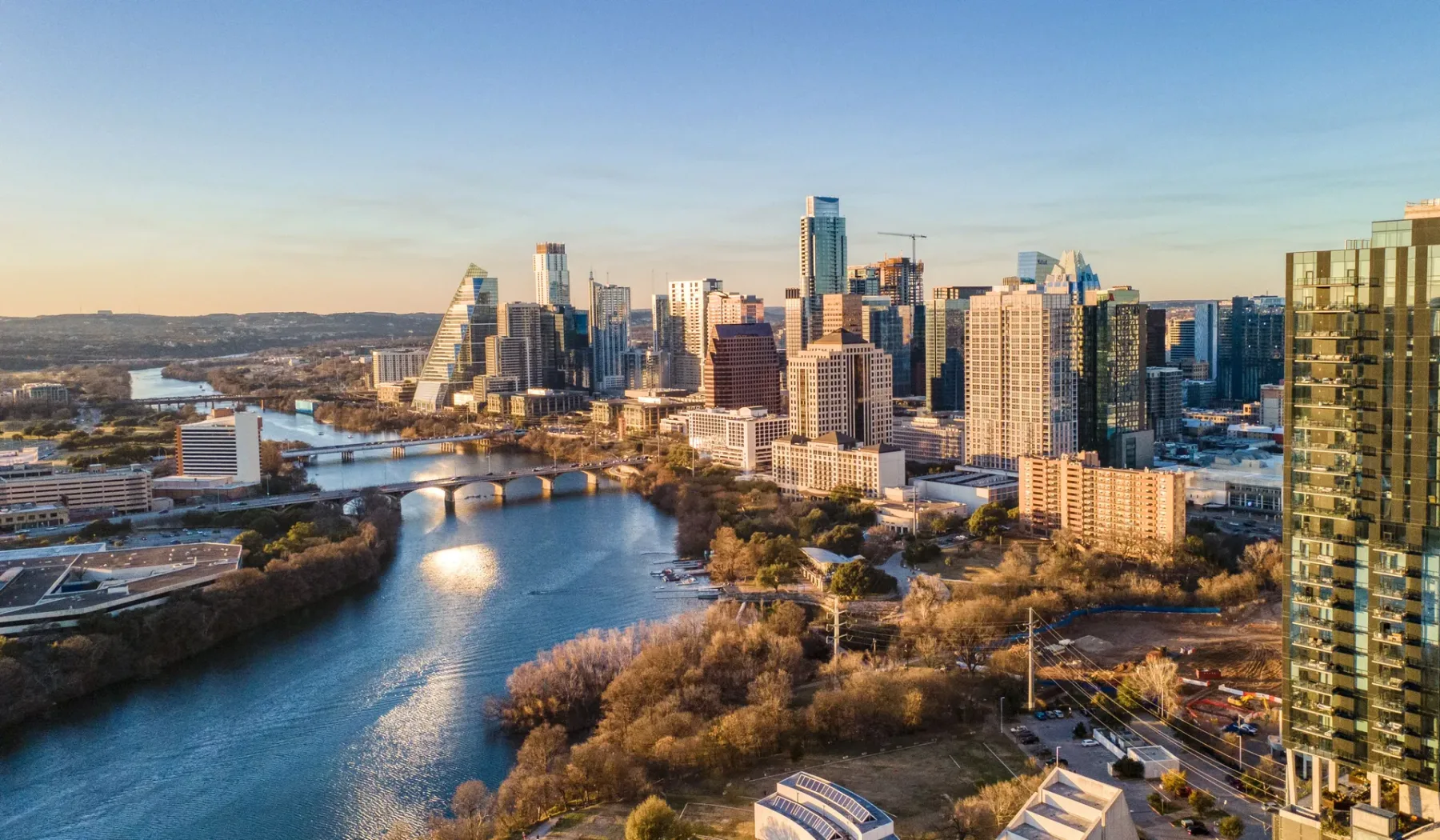 City skyline beside a winding river, with buildings lining both banks.