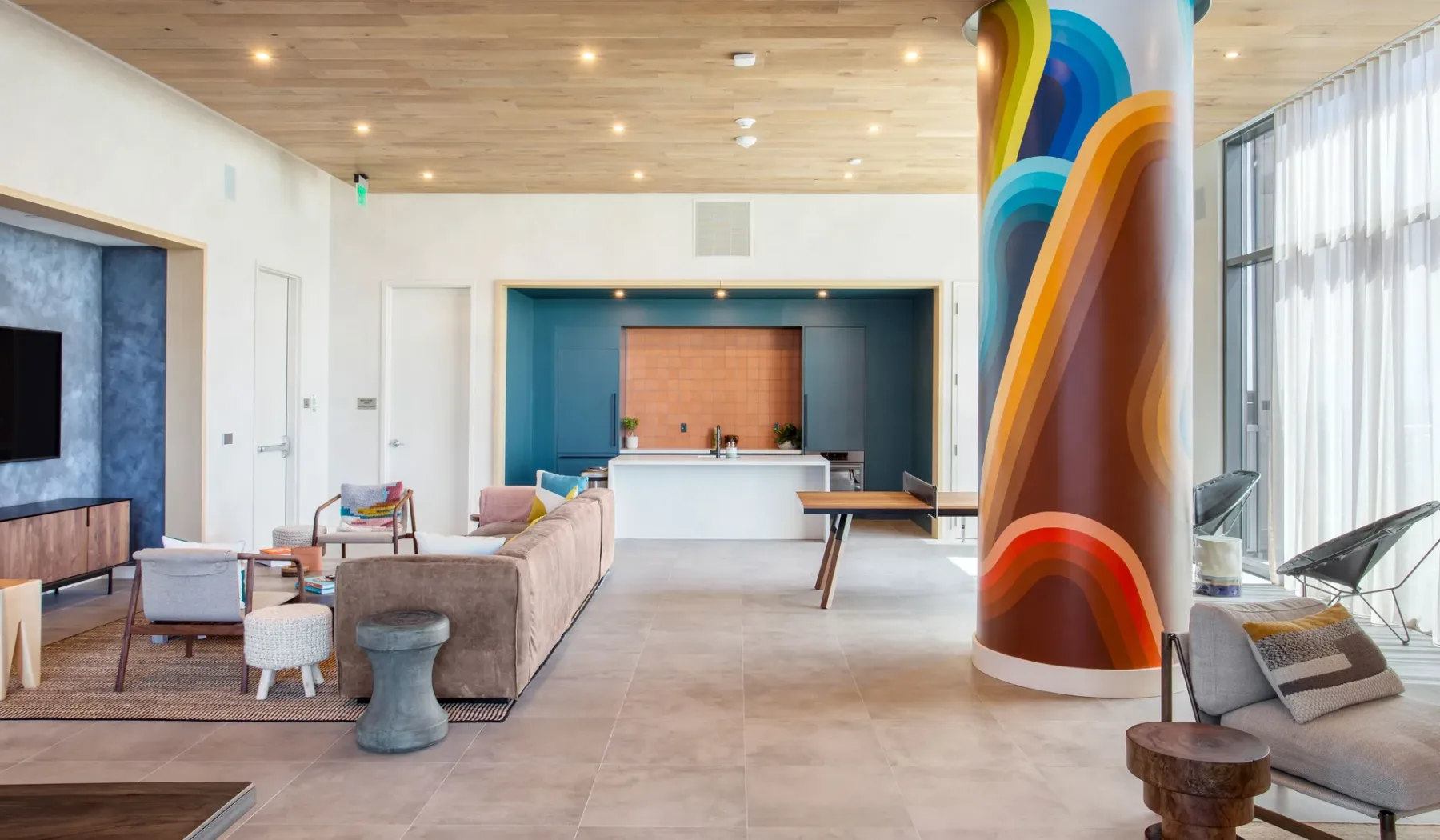 A spacious lounge with seating, a reception desk, and a colorful column.