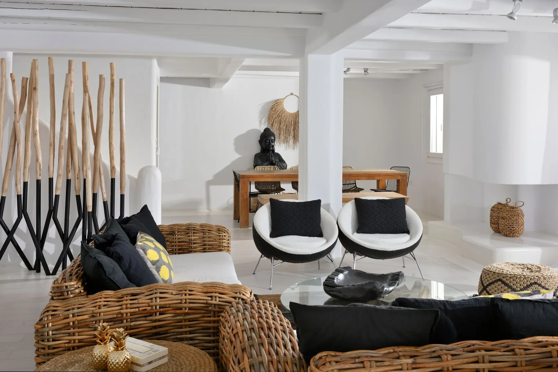 A bright living room with woven seating, modern chairs, and a dining table.