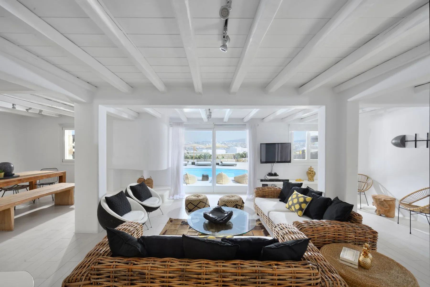 Bright living room with woven seating arranged around a glass coffee table.