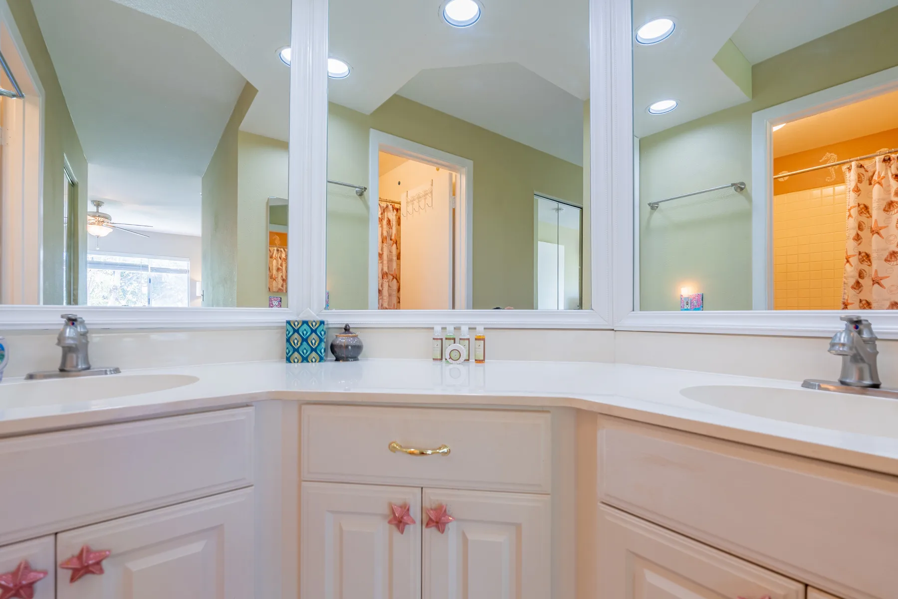 Un tocador de baño con un espejo amplio y lavabos bajo luces de techo.