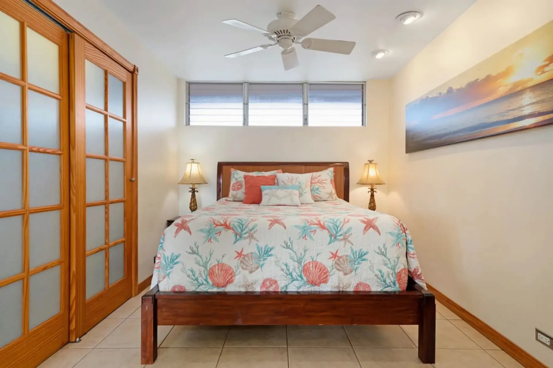 Un dormitorio con una cama de madera, ropa de cama floral y puertas corredizas.