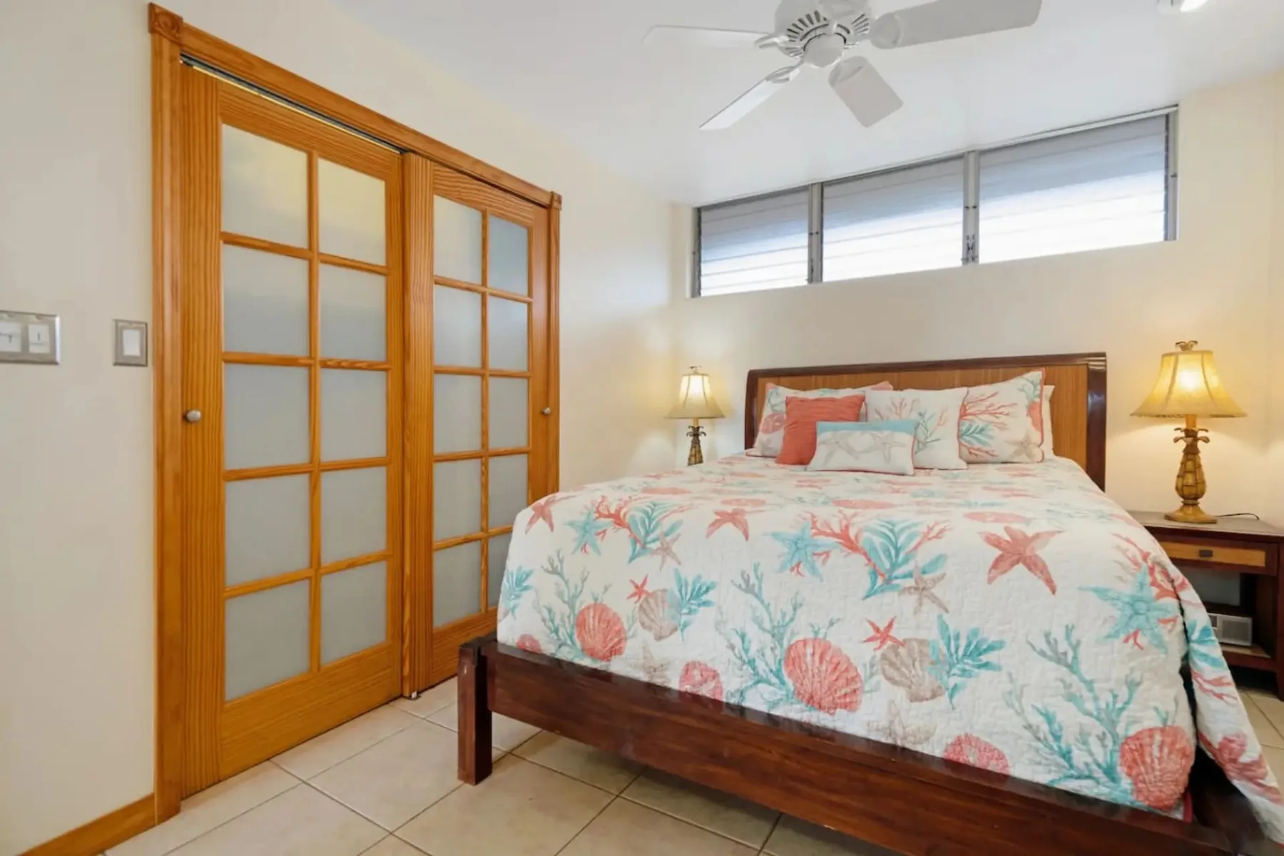 Un dormitorio con una cama de madera, ropa de cama floral y puertas corredizas.