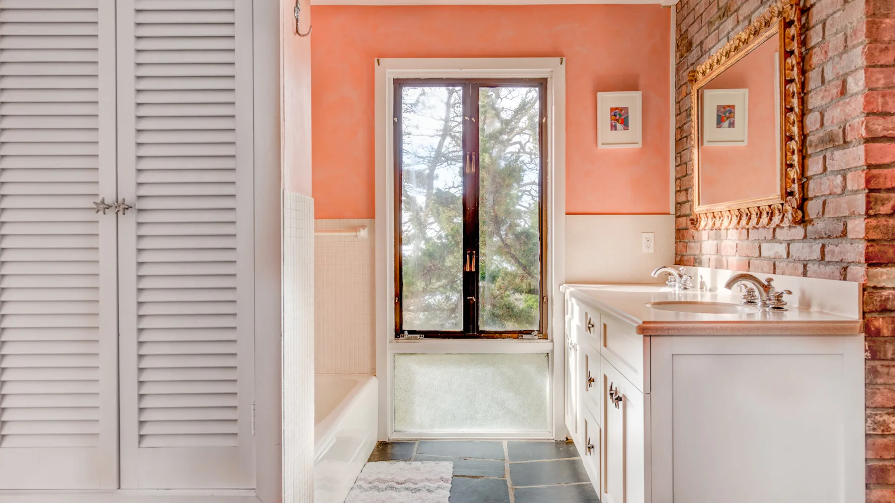 Un baño con un tocador y una ventana al fondo.