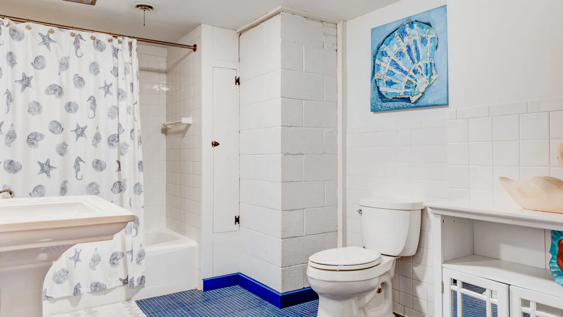 Un baño con azulejos, bañera, cortina de ducha e inodoro.