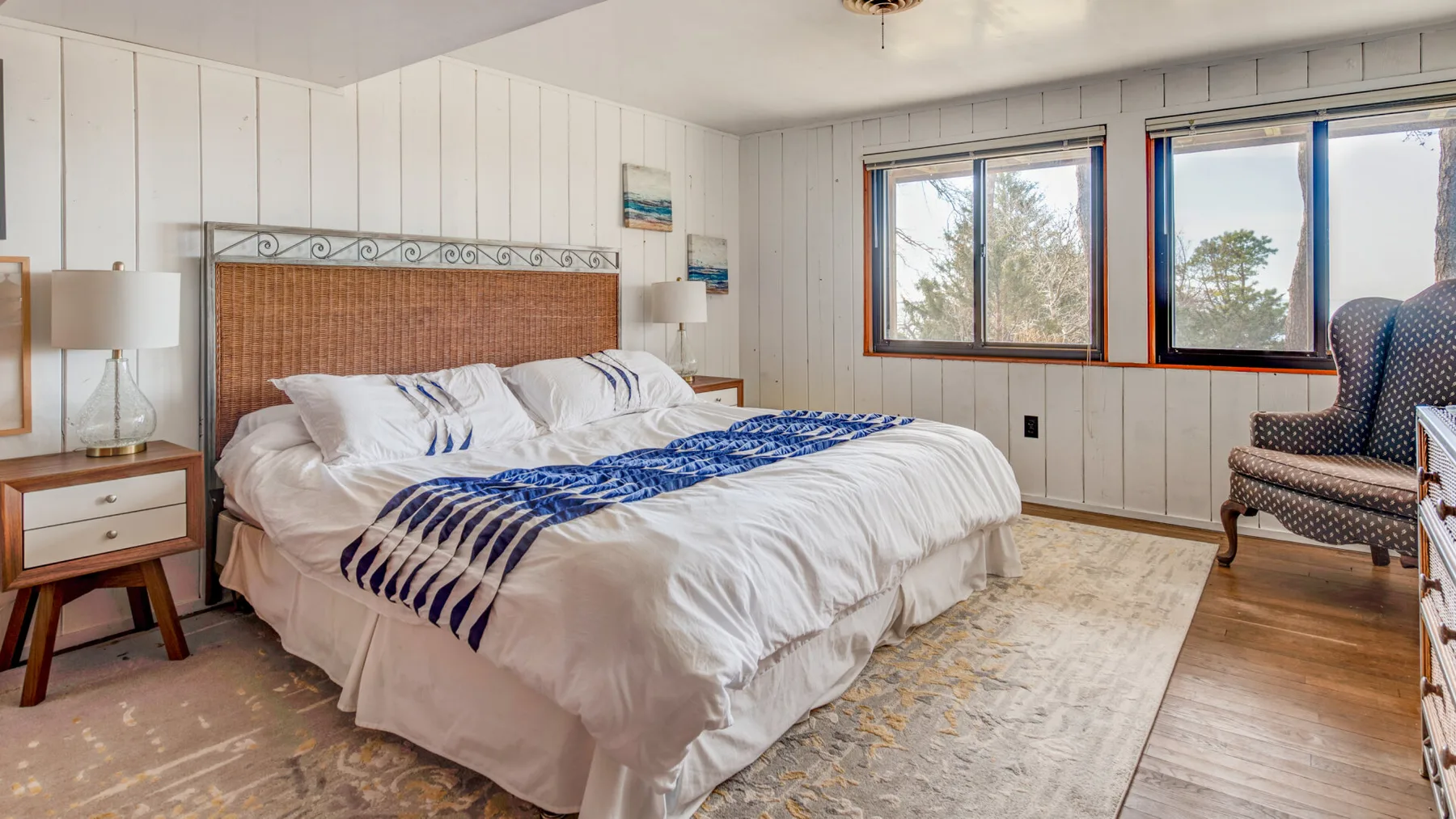 Un dormitorio con una cama vestida de blanco y detalles azules.